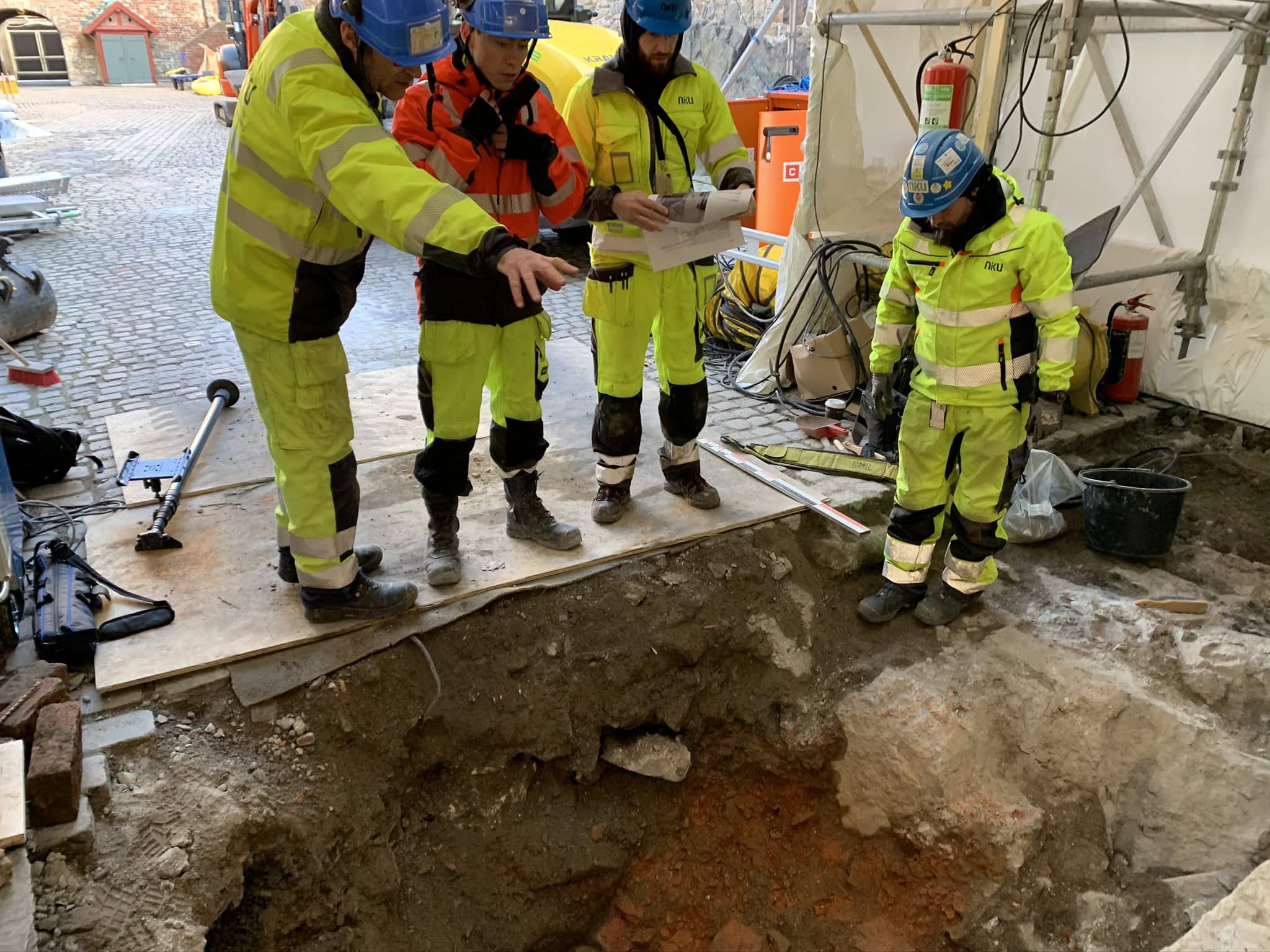 Her diskutterer NIKUs arkeologer betydningen av denne middelalderske teglsteinsmuren.