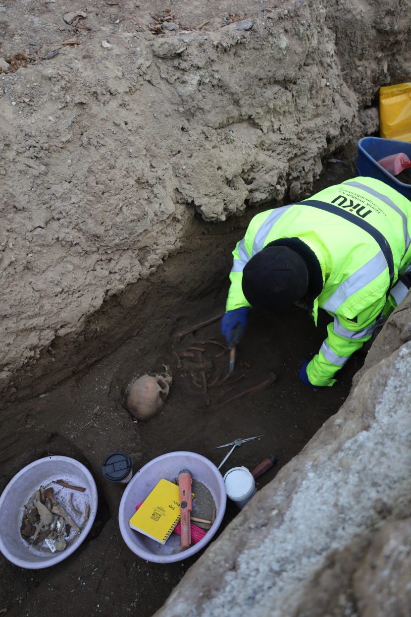 Arkeolog Silje Sandø Rullestad renser frem et godt bevart skjelett. Underkroppen var fjernet av moderne inngrep.