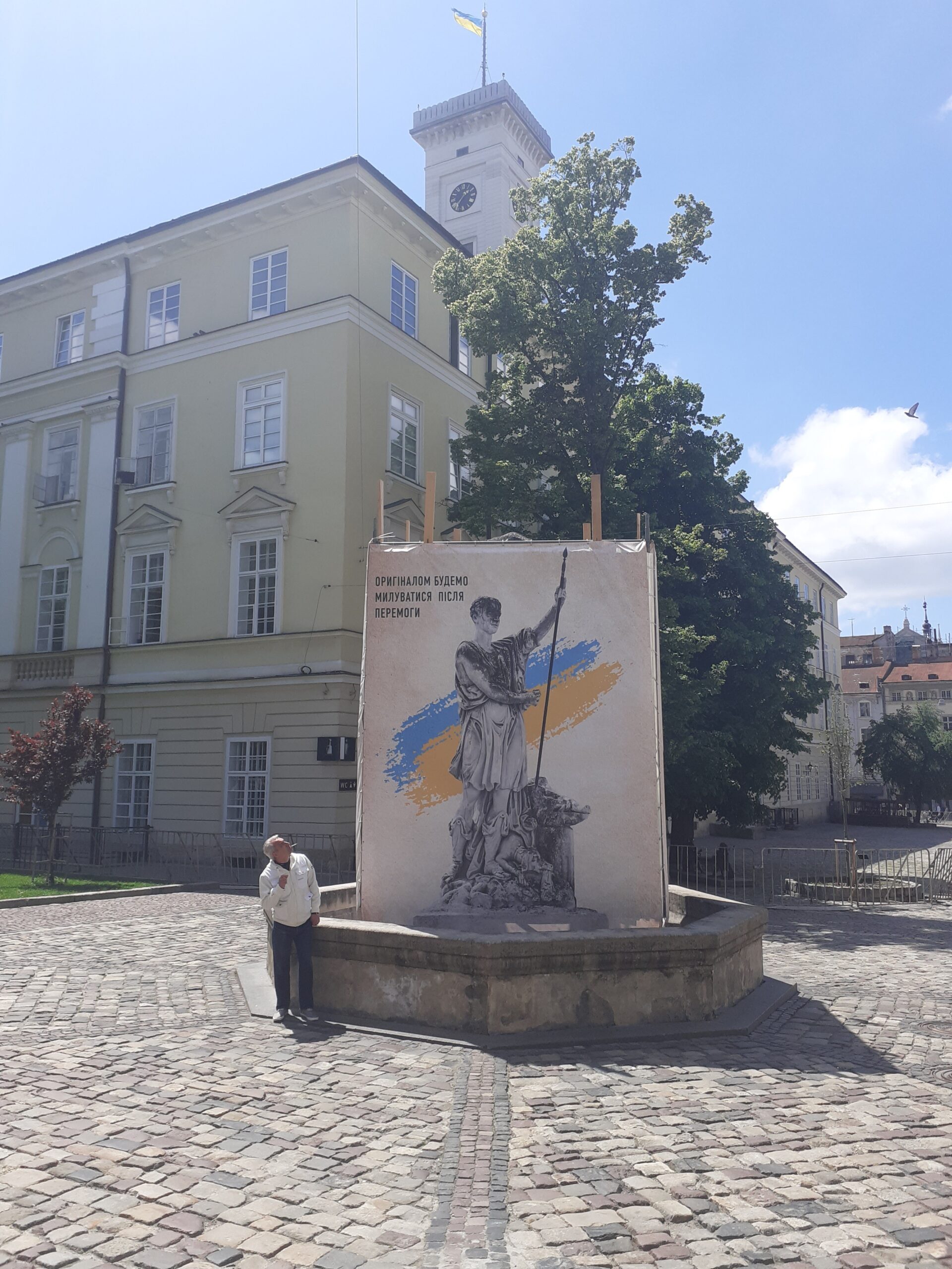 Rynok Square statues are removed and stored safely, the banner shows the statue, saying “The original will be returned after victory”, May 2022, Lviv. Foto Diana Vonnak