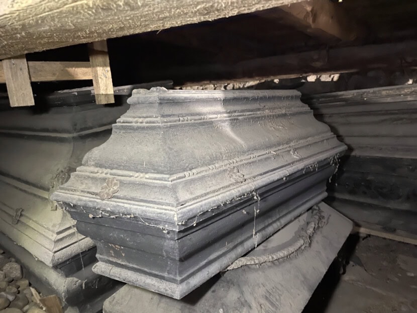 Profilert barnekiste fra under gulvet i Solum kirke. Kisten er svart og nedstøvet.